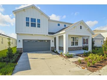 Two-story house with gray garage door and stone accents at 2978 Sharp Rd, Kissimmee, FL 34744