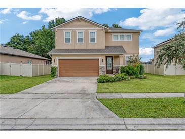 Two-story home with a large two-car garage and front yard at 3871 Pinewood Gardens, Saint Cloud, FL 34769