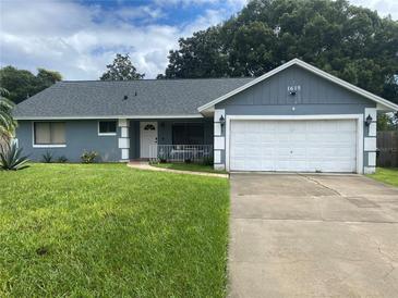 Ranch style home with gray exterior and attached garage at 1615 Martinsville Ct, Orlando, FL 32825