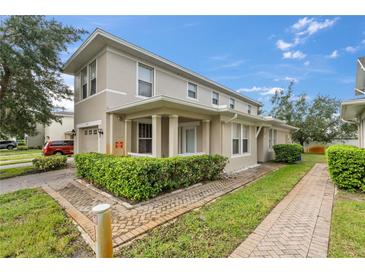 Tan two-story home with attached garage and landscaping at 2078 Cypress Bay Blvd, Kissimmee, FL 34743