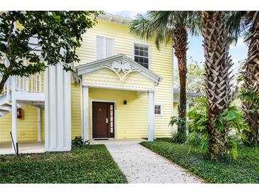Charming yellow two-story building with lush landscaping and welcoming entrance at 306 Lucaya Loop # B5/U306, Davenport, FL 33897
