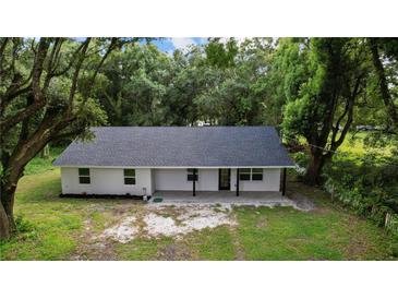 Newly constructed home with a white exterior, gray roof, and a spacious yard at 424 Wilder Rd, Lakeland, FL 33809