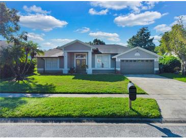 Single story home with a gray exterior, two-car garage and green lawn at 5232 Deer Creek Dr, Orlando, FL 32821
