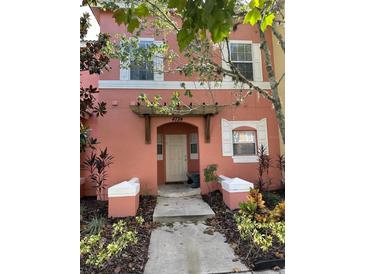Two-story home with peach-colored exterior and walkway at 4734 Vero Beach Pl, Kissimmee, FL 34746
