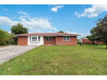 Brick home with a large yard, and driveway at 7819 Puritan Rd, Orlando, FL 32807