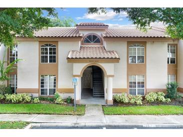 Front view of condo building with stairs and entrance at 4611 Gate Pl # H-203, Orlando, FL 32811