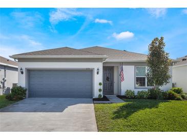 One-story home with gray garage door and landscaped lawn at 2195 Bluebird Pl, St Cloud, FL 34771