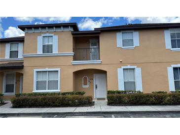 Tan two-story townhome with white trim at 2716 Bushman Dr, Kissimmee, FL 34746