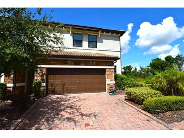 Two-story home with brown garage door and stone accents at 8501 Arcadia Ln, Davenport, FL 33896