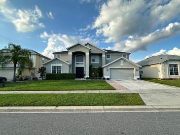 Two-story house with a gray exterior, landscaping, and a two-car garage at 2321 Hinsdale Dr, Kissimmee, FL 34741