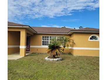 Tan house with brown roof, landscaping, and a covered entryway at 1325 Dunbarton Ct, Kissimmee, FL 34758
