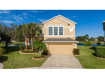 Two-story house with a neutral exterior, landscaped yard, and a two-car garage at 1542 Sun Meadow Dr, Orlando, FL 32824