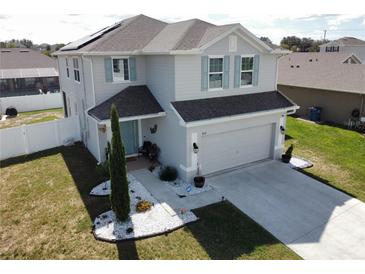 Two-story house with gray siding, solar panels, and a two-car garage at 4531 Brooksshire Pl, Lake Wales, FL 33898