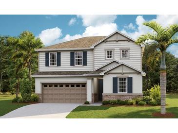 Two story home with beige siding, stone accents, and a two car garage at 4227 Sawtooth Ct, Tavares, FL 32778