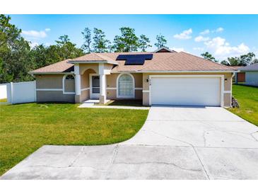 Single-story home with attached garage and solar panels at 119 Talavera Ln, Kissimmee, FL 34758