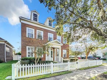 Brick home with white picket fence and dormer windows at 307 Norfolk St, Celebration, FL 34747