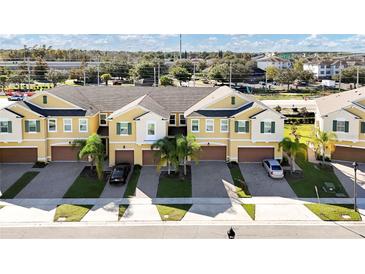 Aerial view of townhouses with garages and palm trees at 9824 Red Eagle Dr, Orlando, FL 32825
