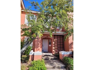 Two-story home with a peach facade and a white door at 153 Pompano Beach Dr, Kissimmee, FL 34746