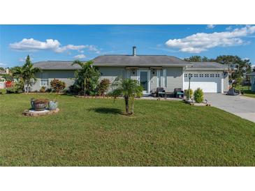 Ranch-style home with a well-maintained lawn, driveway, and garage at 1395 Emerald Dr, Kissimmee, FL 34744