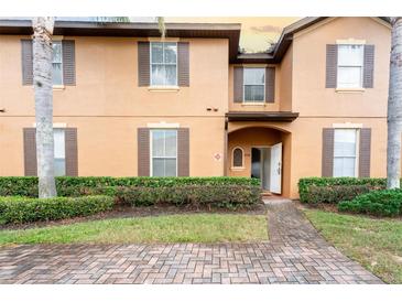 Two-story townhome with brick walkway and landscaping at 4224 Calabria Ave, Davenport, FL 33897