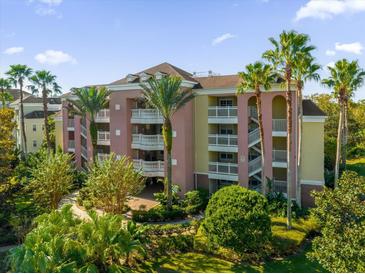 Attractive condo building with lush landscaping and palm trees at 7662 Whisper Way # 402, Reunion, FL 34747