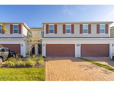 Two-story townhome with a two-car garage and landscaped yard at 4919 Conifer Cone Dr, Kissimmee, FL 34746