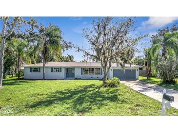 Newly renovated single story home with gray garage door and well-manicured lawn at 905 Valencia Rd, South Daytona, FL 32119