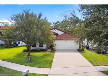 Single-story home with a red tile roof and attached garage at 9016 Murano Mews Ct, Kissimmee, FL 34747