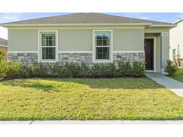 Single-story house with stone accents and landscaping at 6883 Botanic Blvd, Harmony, FL 34773