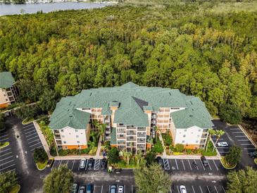 Aerial view of a multi-unit building with green roof and ample parking at 9051 Treasure Trove Ln # 307, Kissimmee, FL 34747