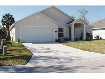 One-story house with attached garage and landscaped front yard at 236 Paradise Woods Ct, Davenport, FL 33896