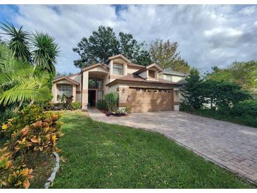 Two-story house with a brown garage door and landscaped yard at 325 Sonoma Valley Cir, Orlando, FL 32835