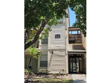 Building exterior, featuring a light-colored facade and landscaping at 1940 Lake Atriums Cir # 93, Orlando, FL 32839
