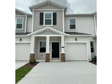 Two-story home with two-car garage and landscaping at 2720 Pierr St, Davenport, FL 33837