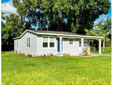 Newly renovated home with gray siding, landscaping, and a blue door at 639 Shore Acres Dr, Lakeland, FL 33801