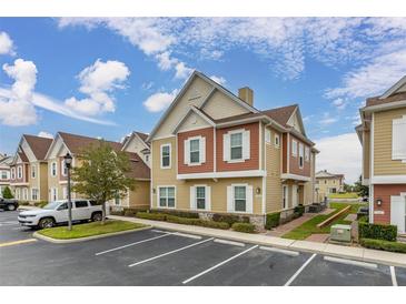 Two-story townhouse boasts attractive exterior with a landscaped walkway at 7585 Sunny Dreams Ln, Kissimmee, FL 34747