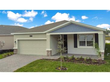 One-story house with gray siding, a two-car garage, and a landscaped yard at 2971 Camden Way, Davenport, FL 33837