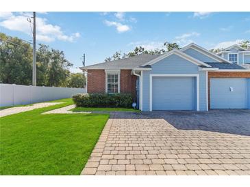 Front view of a light blue and brick home with a garage at 3401 Home Town Ln, St Cloud, FL 34769