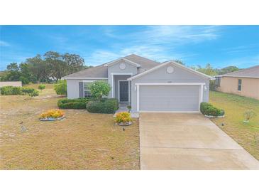 One-story home with gray siding, attached garage, and landscaping at 2649 Sunset Cir, Lake Wales, FL 33898