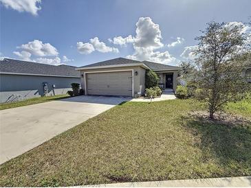 House exterior features a two car garage and well maintained lawn at 502 Pentas Ln, Haines City, FL 33844