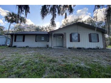 Ranch-style home with a spacious yard and mature trees at 1604 Royal Palm Dr, Edgewater, FL 32132