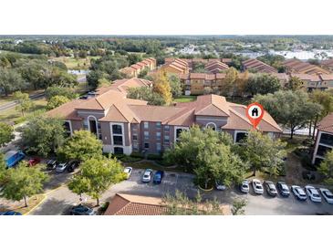 Aerial view of condo building with parking and landscaping at 6141 Metrowest Blvd # 307, Orlando, FL 32835