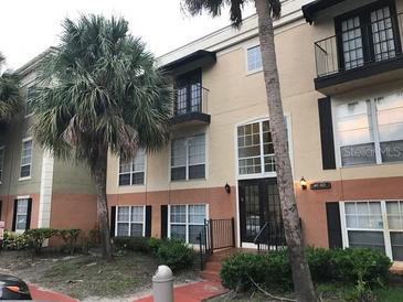 Exterior view of a two-story condo building with palm trees at 4119 Dijon Dr # 4119H, Orlando, FL 32808