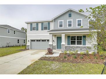 Two-story house with gray siding, teal shutters, and stone accents at 680 Summit River Dr, Apopka, FL 32712