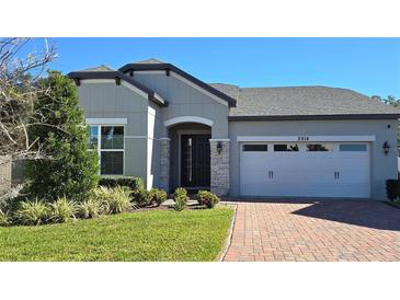 Attractive single-story home with gray siding, a two-car garage, and a brick driveway at 2914 Scarlett Dr, Saint Cloud, FL 34772