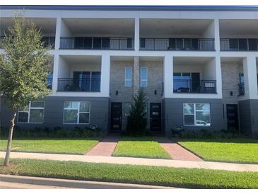 Modern three-story townhouses with private balconies and landscaped lawn at 9778 Bucklow Hill Dr, Orlando, FL 32832
