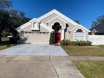 Two-story house with a red door and attached garage at 2213 Rio Pinar Lakes Blvd, Orlando, FL 32822