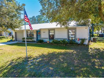 Front view of a ranch home with American flag and well-maintained lawn at 6446 Creation St, Saint Cloud, FL 34771