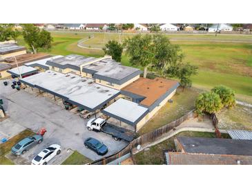 Aerial view of a multi-unit residential building with ample parking and surrounding green space at 2203 Silver Pines Pl # 601, Orlando, FL 32808