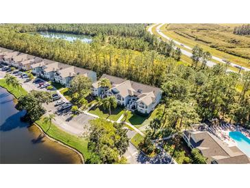 Aerial view of a condo community near a lake and highway at 2022 Royal Bay Blvd # 94, Kissimmee, FL 34746